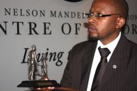Sello Hatang accepts a medal presented to Mandela by Lions International