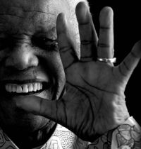 Nelson Mandela, with hand raised in front of his face (large image)