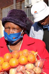 A woman receives oranges at an E1 F1 food distribution at Bodibe