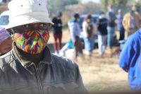 A man in a mask at an E1 F1 food distribution at Bodibe 