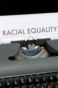 typewriter and "racial equality" typed on a sheet of paper